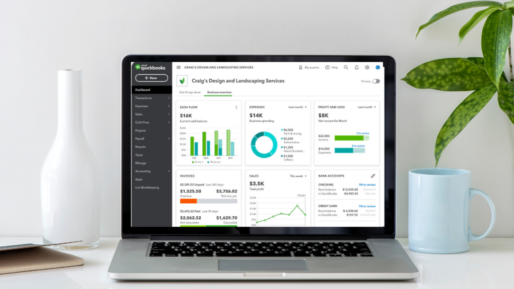 Clean desk with laptop displaying QuickBooks dashboard